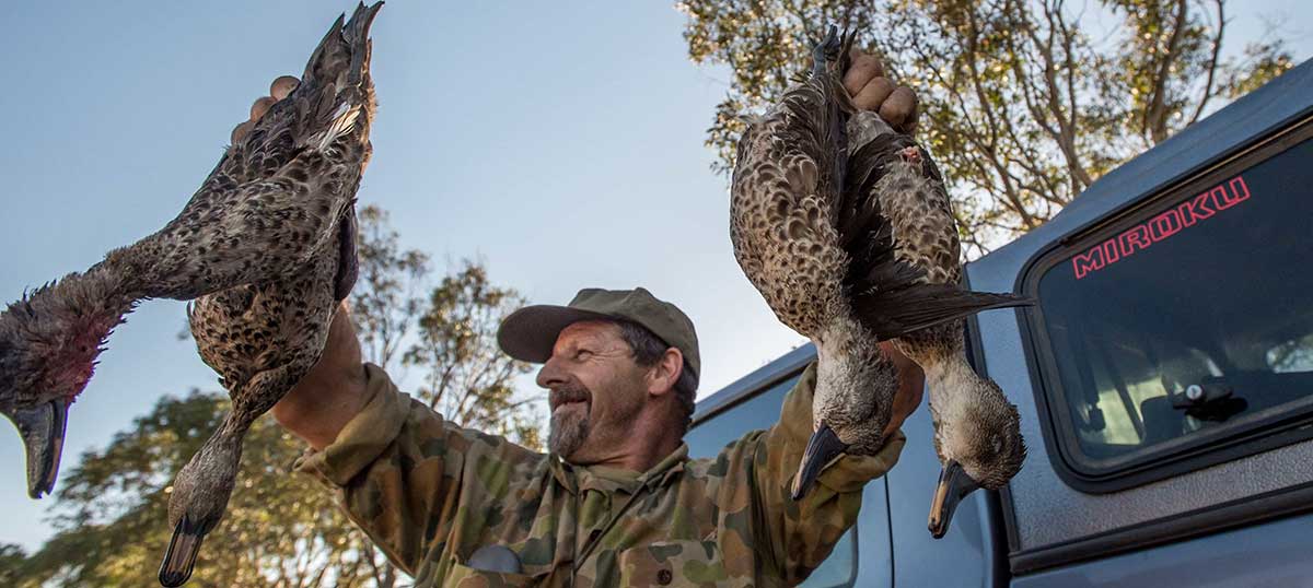 Image shows hunter posing with dead ducks