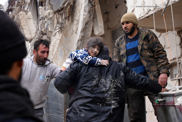 A child is being protected from rubble in Jandaris, Syria, after earthquakes shocked the country. 