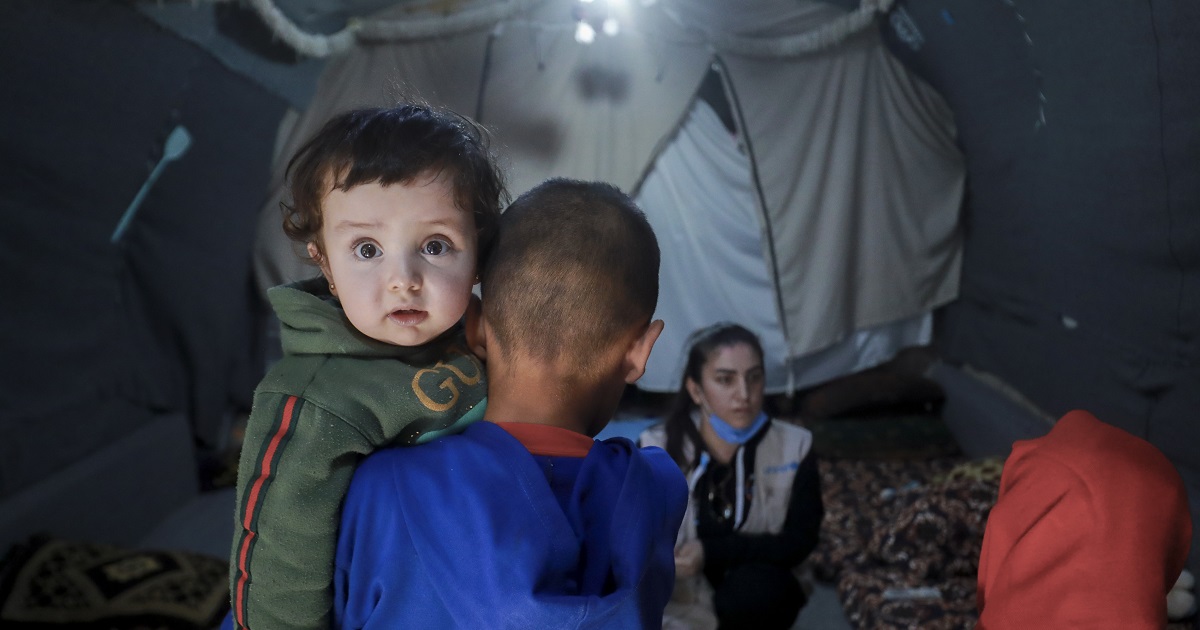 Muhammad, âgé de 11 ans, tient sa petite sœur, Aya, dans leur tente du camp de Roj, un camp pour personnes déplacées en Syrie.