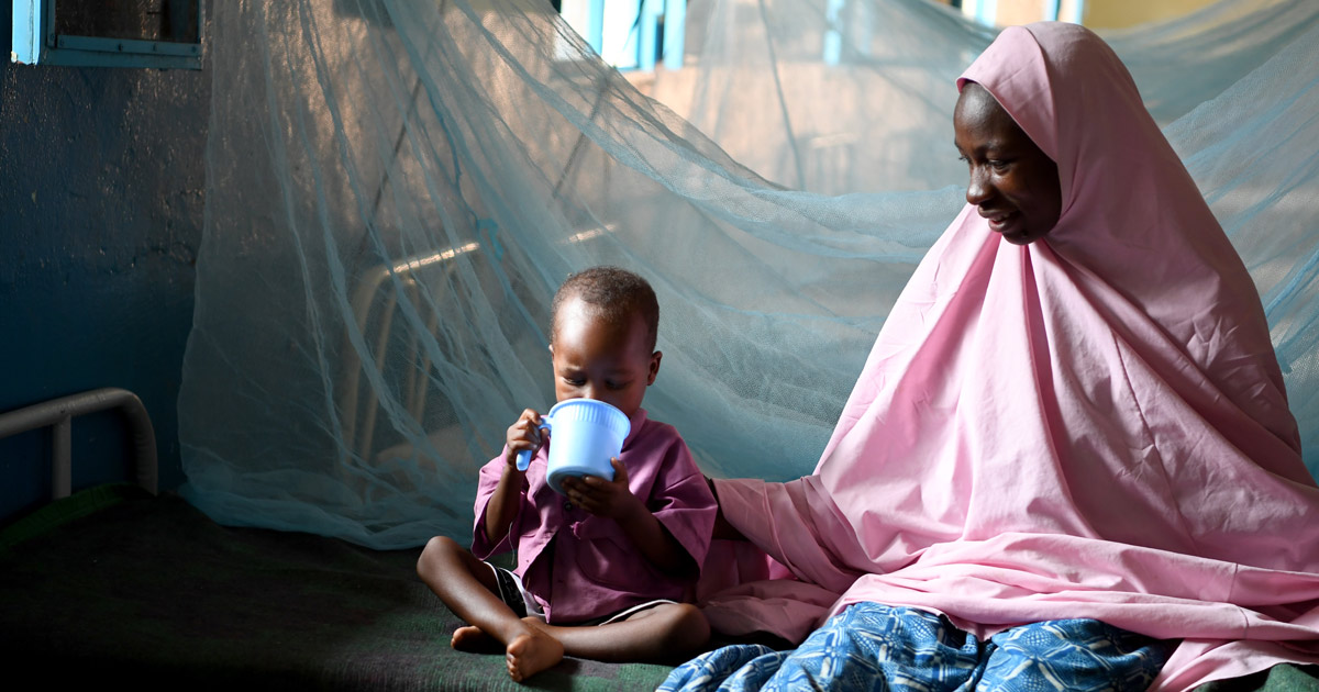 4-year-old Oumar who is recovering from malnutrition, drinks from a cup accompanied by his mother Rakia, 28