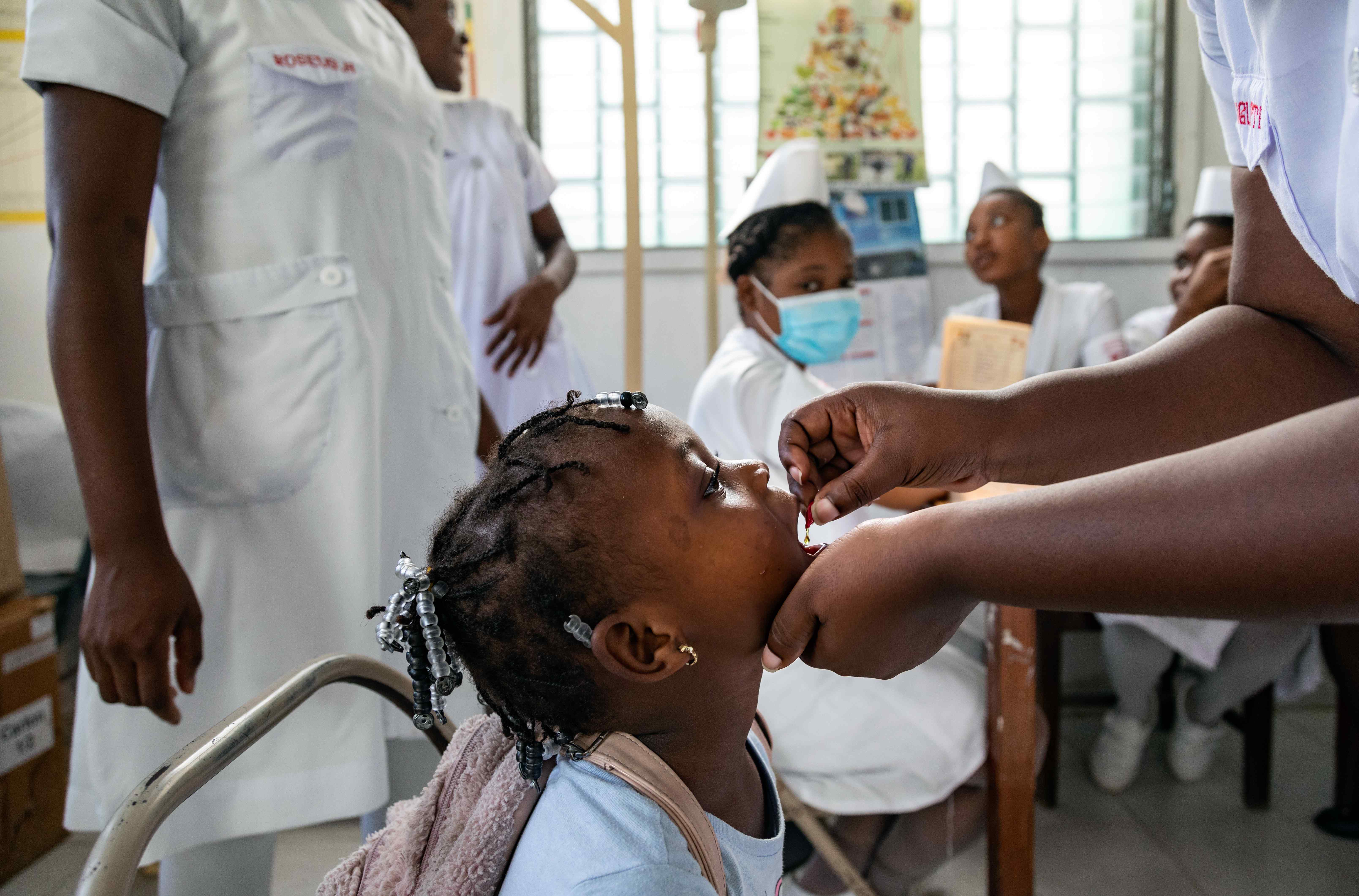 Une jeune fille reçoit une dose de vitamine A dans un hôpital en Haïti.