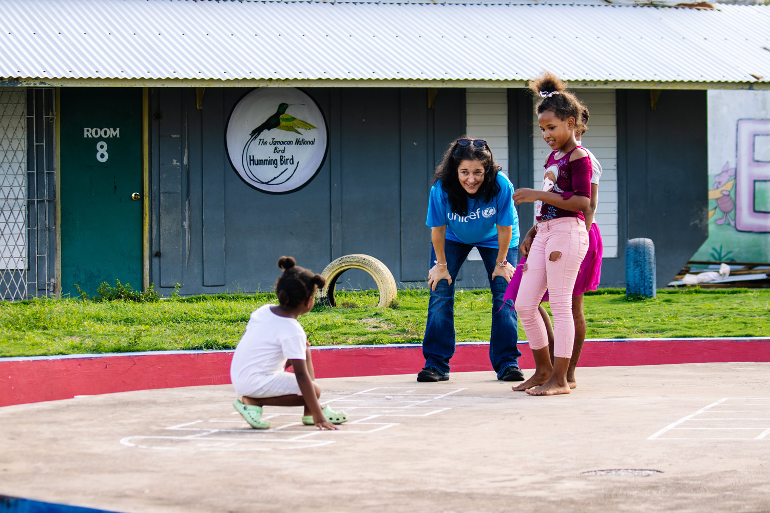 Education Specialist at UNICEF Jamaica plays with children in front of school