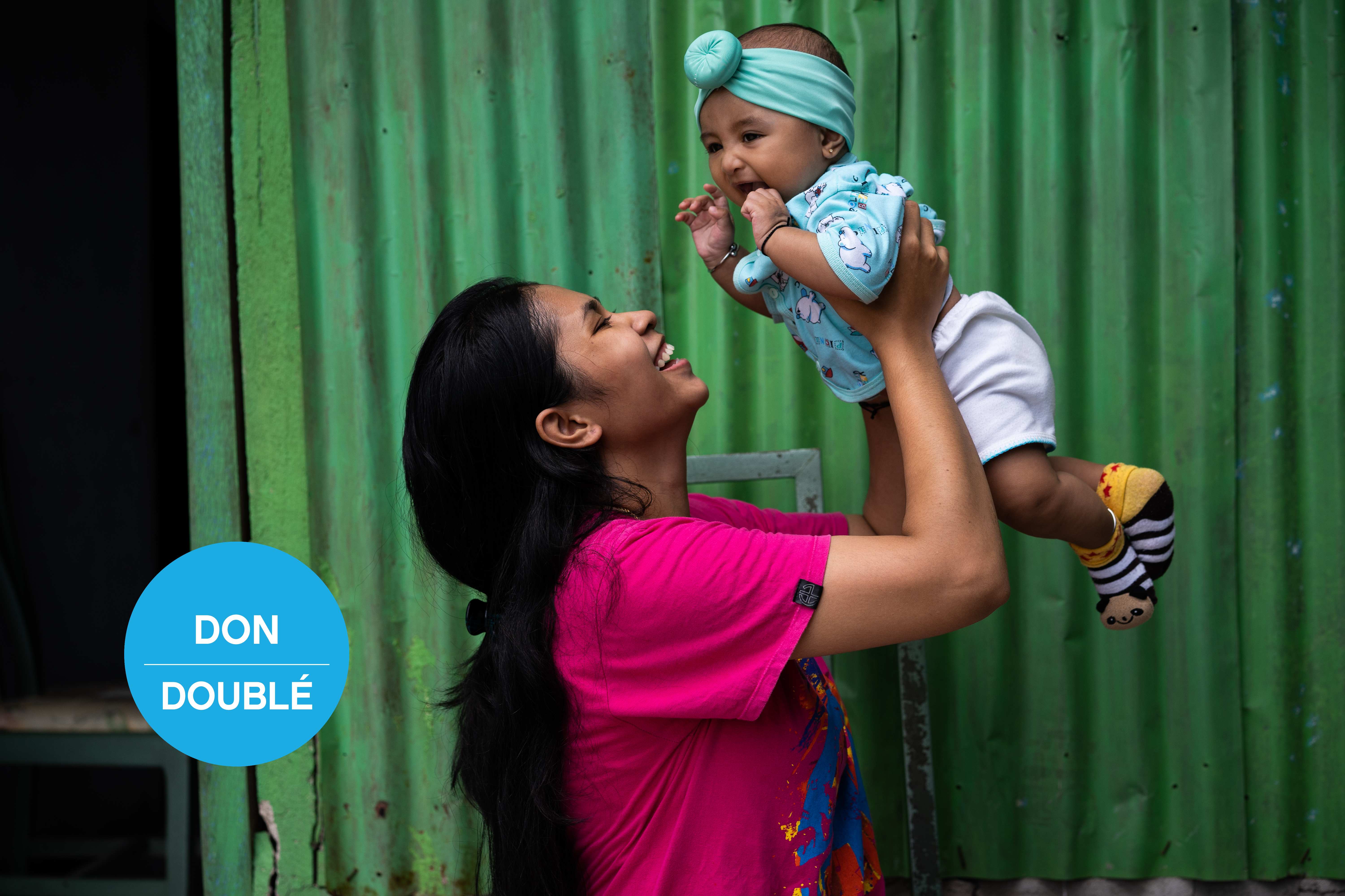 Enciana célèbre après que sa fille Fayra a reçu son vaccin contre la poliomyélite dans un centre de santé soutenu par l’UNICEF en Indonésie.