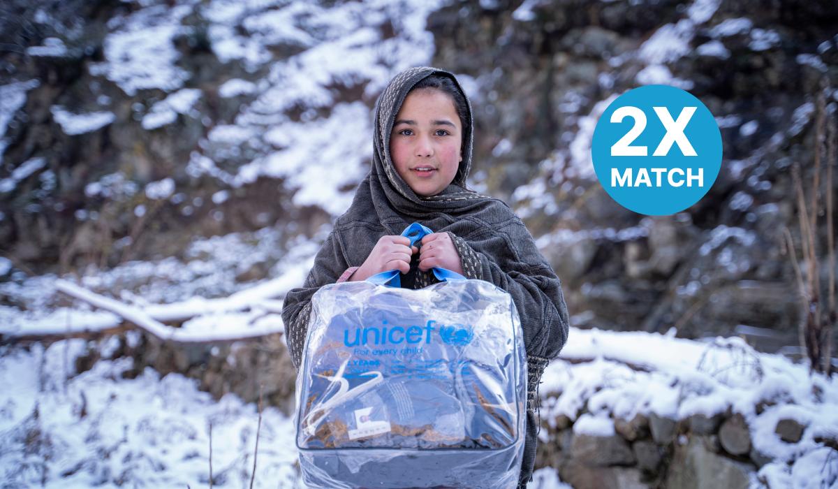 Young girl with a UNICEF package of clothes/blanket in the snow in Pakistan 

 