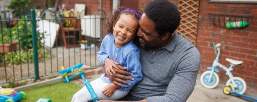 Man with his daughter sat on his knee