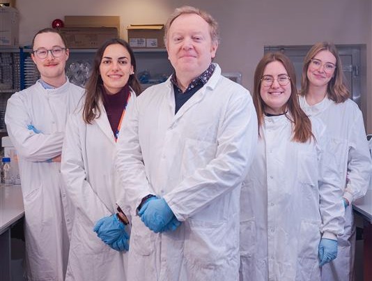 Photo of 5 scientists looking into camera