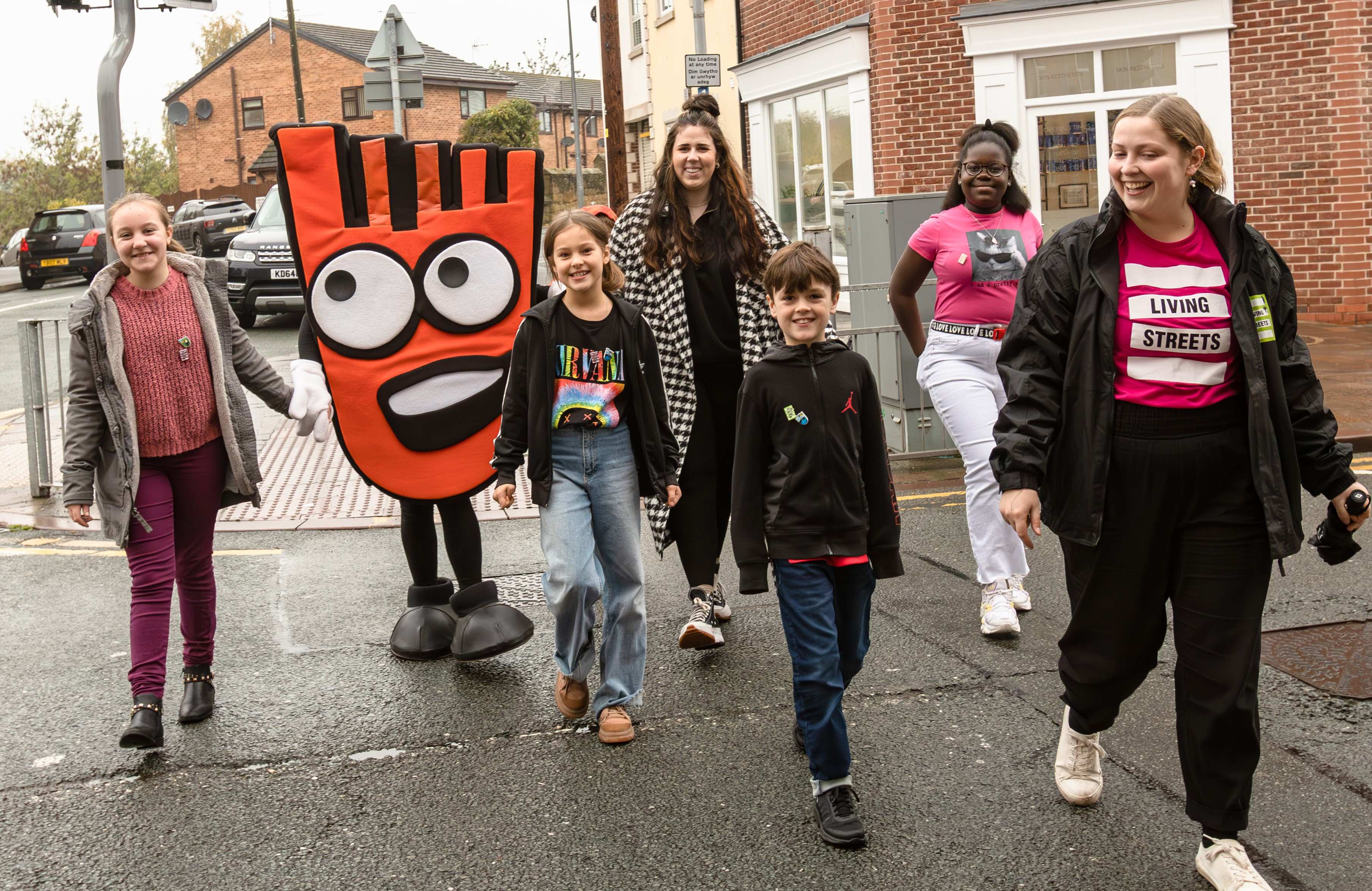 Group of people smiling while crossing the road