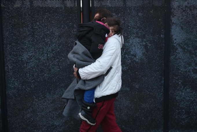  man from Syria walks to a police van with his daughter in Denmark after police found them on a train Jan. 6, 2016. Getty