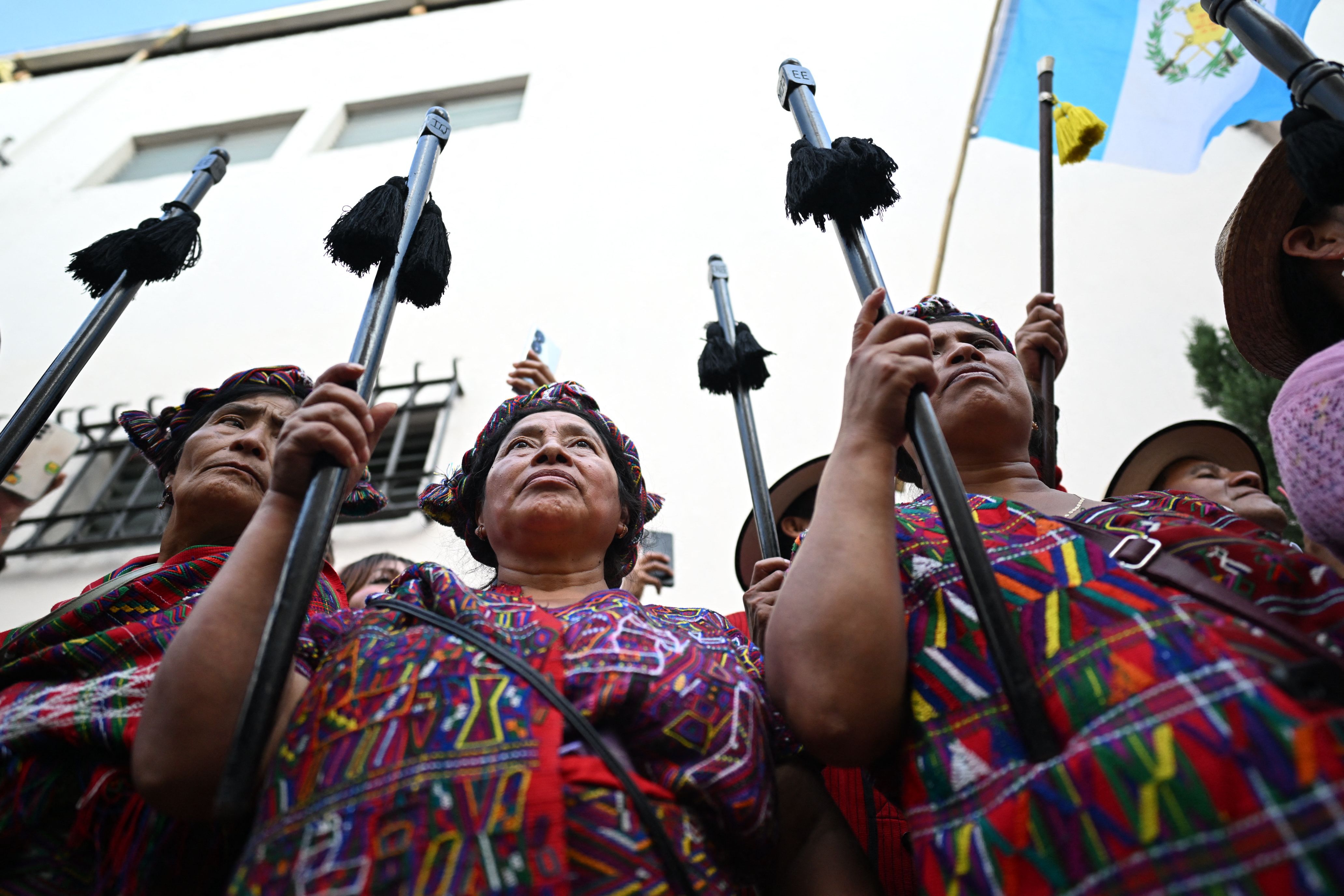 Indigenous leaders hold high their staffs as they take part in a protest demanding the resignation of Attorney General Consuelo Porras and prosecutor Rafael Curruchiche outside the Presidential House, on October 12, 2023