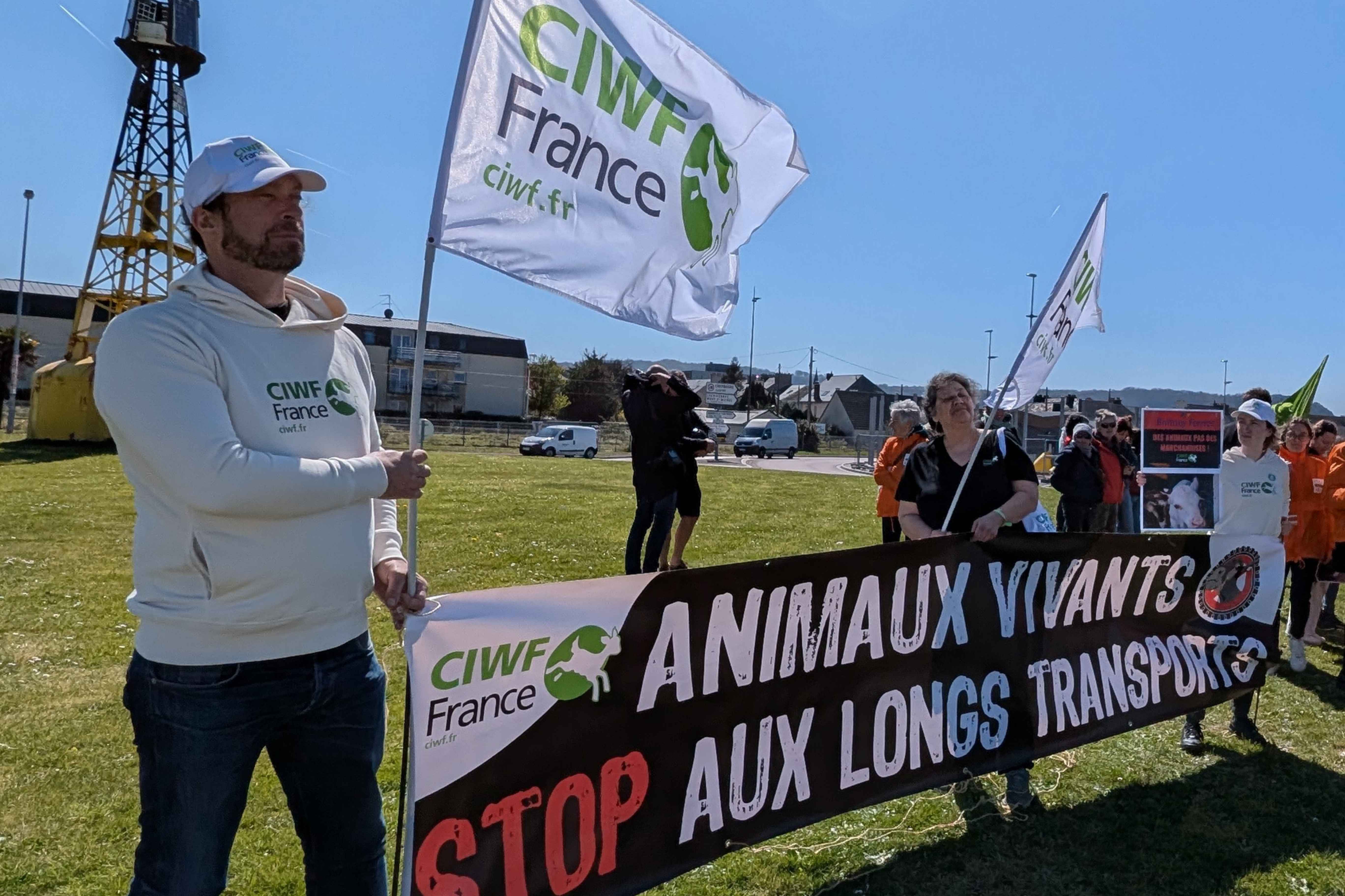 Attivisti e attiviste di CIWF Francia e altre organizzazioni con striscione e cartelli contro il trasporto di animali vivi