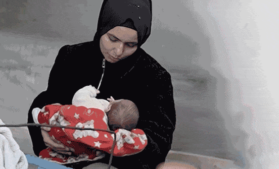 Mother rocking and kissing her baby