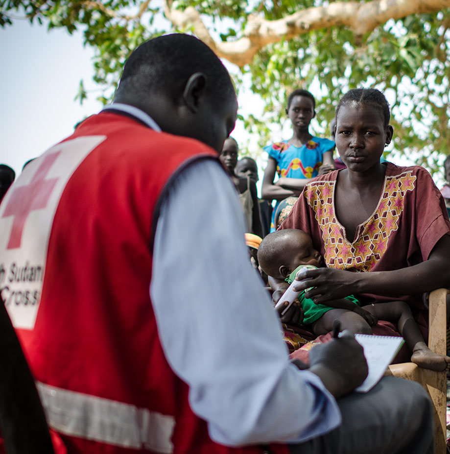 A young mother brings her sick child to visit a Red Cross mobile health clinic in South Sudan.