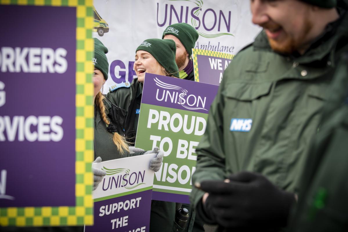 striking NHS staff smile on the picket line