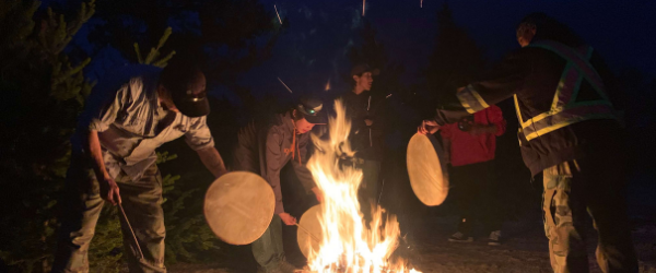 warming drums by a fire in the Seal River Watershed