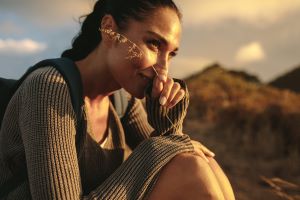 A woman sitting on a mountain top in contemplation.