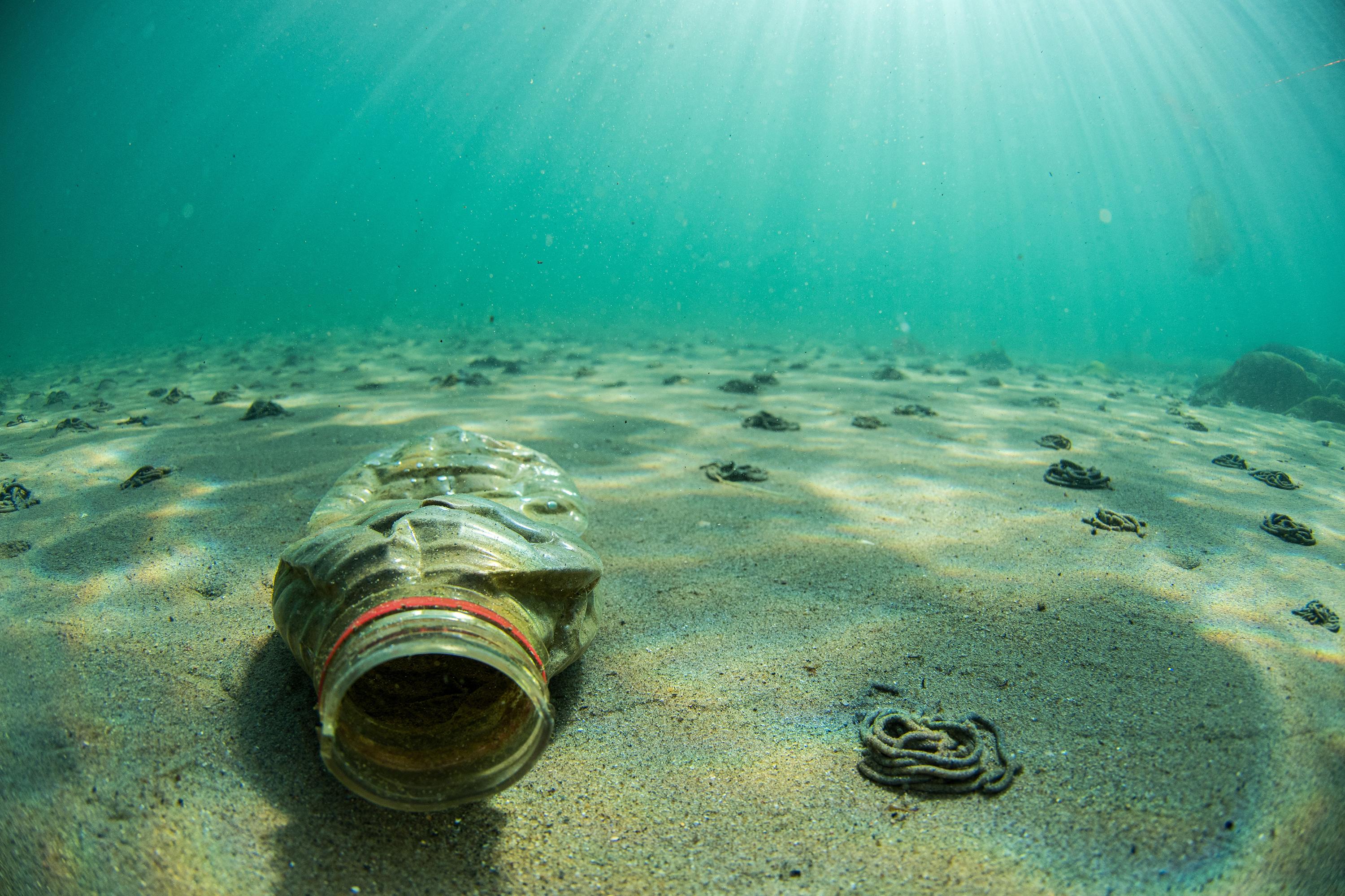 Plastic bottle sitting at bottom of ocean