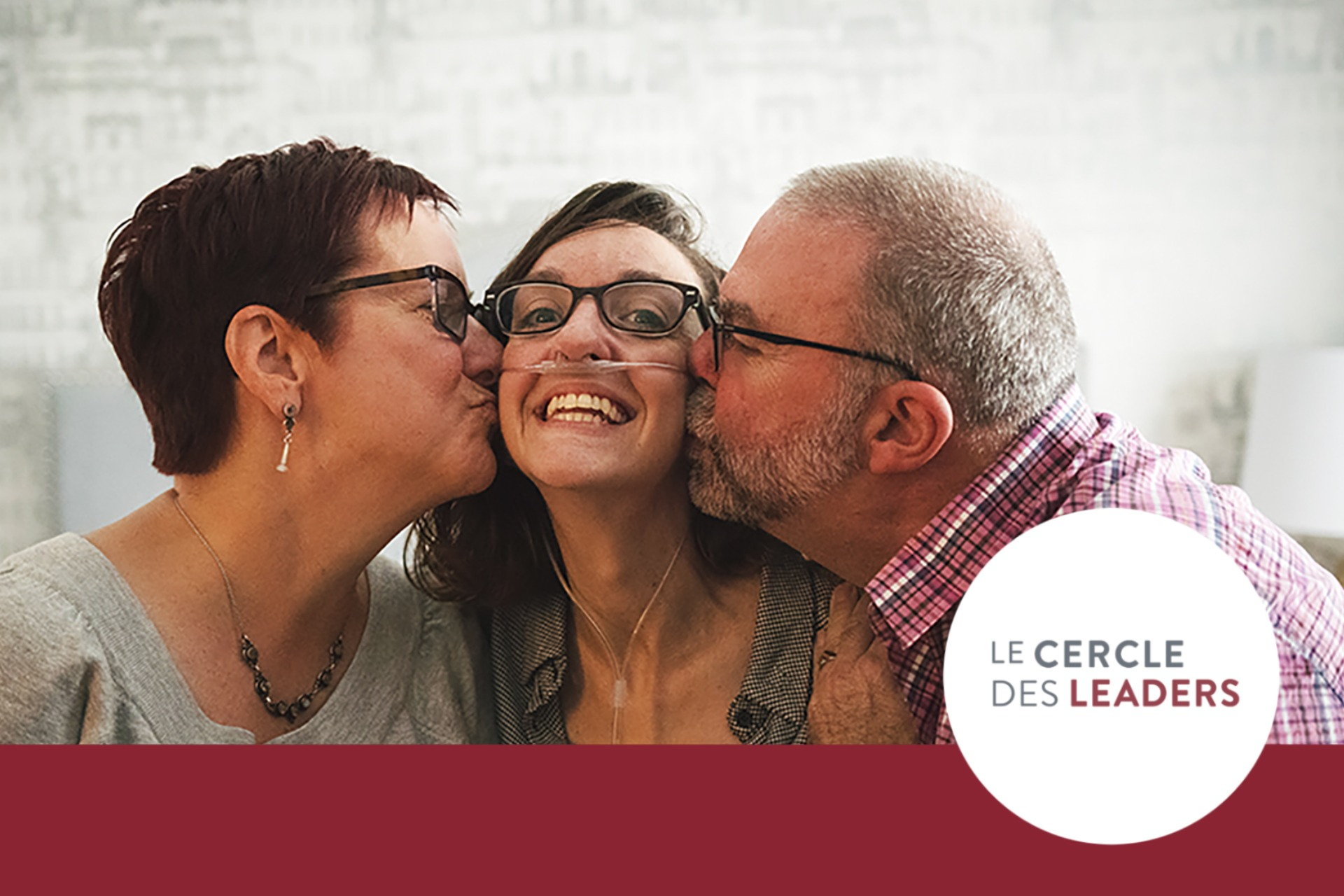 Une mère et un père embrassant leur fille sur la joue.