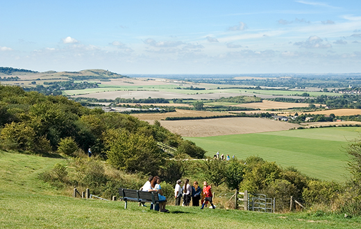 People admiring the view from Ivinghoe Beacon farmland patchwork - credit Shutterstock