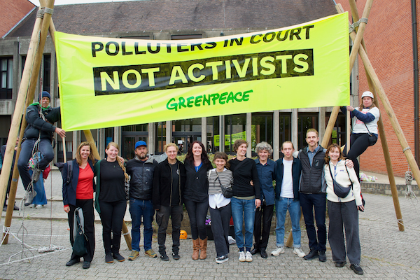 14 activisten met een spandoek met de tekst 