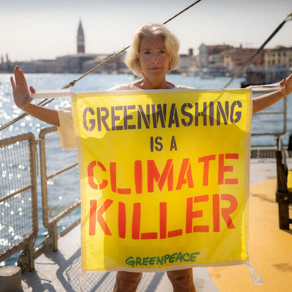 Emma Thompson, aan boord van Greenpeace's Rainbow Warrior in Venetië, steunt het Europese burgerinitiatief (ECI) om reclame en sponsoring voor fossiele brandstoffen in de Europese Unie te verbieden en houdt een spandoek omhoog tegen greenwashing.