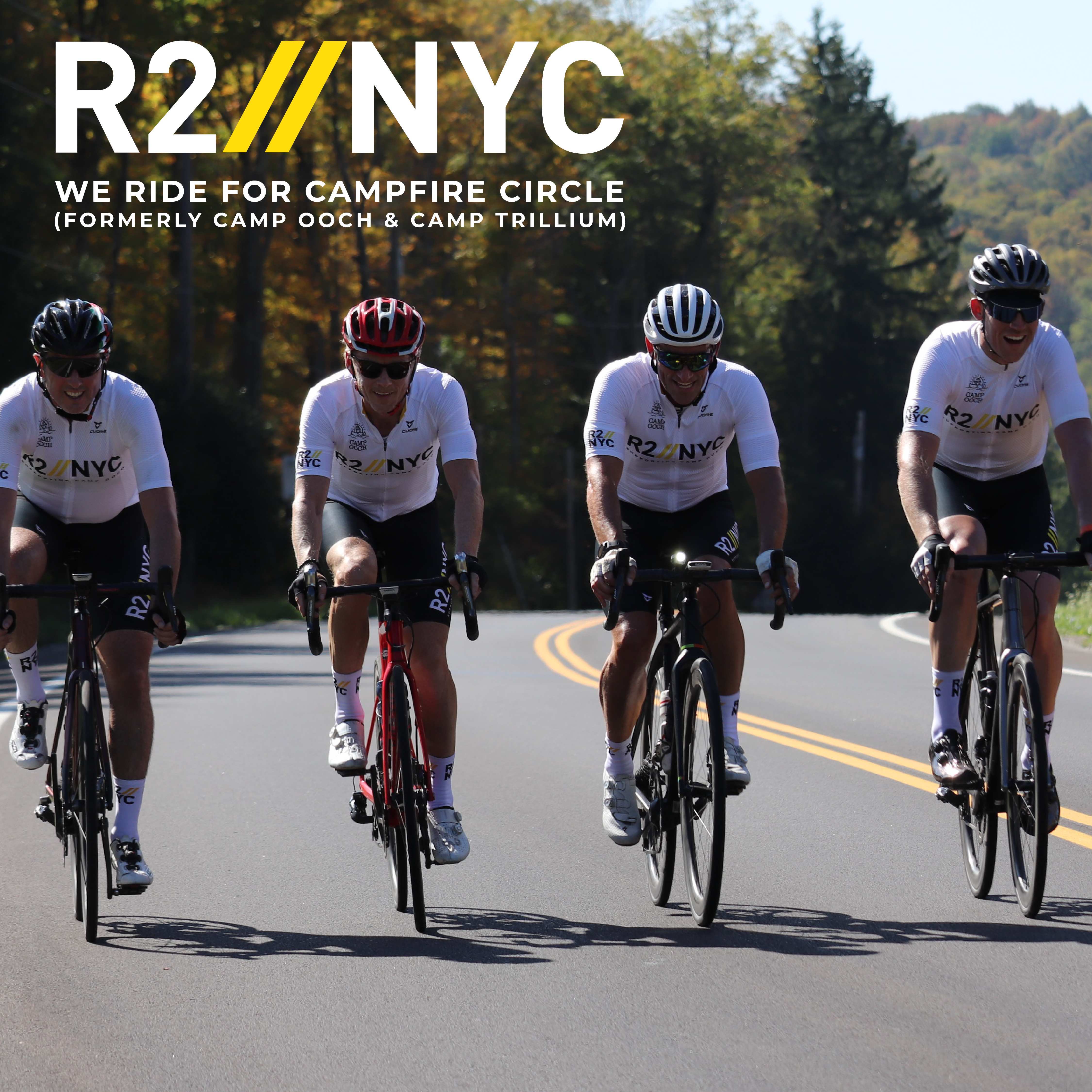 R2NYC We ride for Campfire Circle (Formerly Camp Ooch & Camp Trillium) Four riders on bikes on road with big trees in background