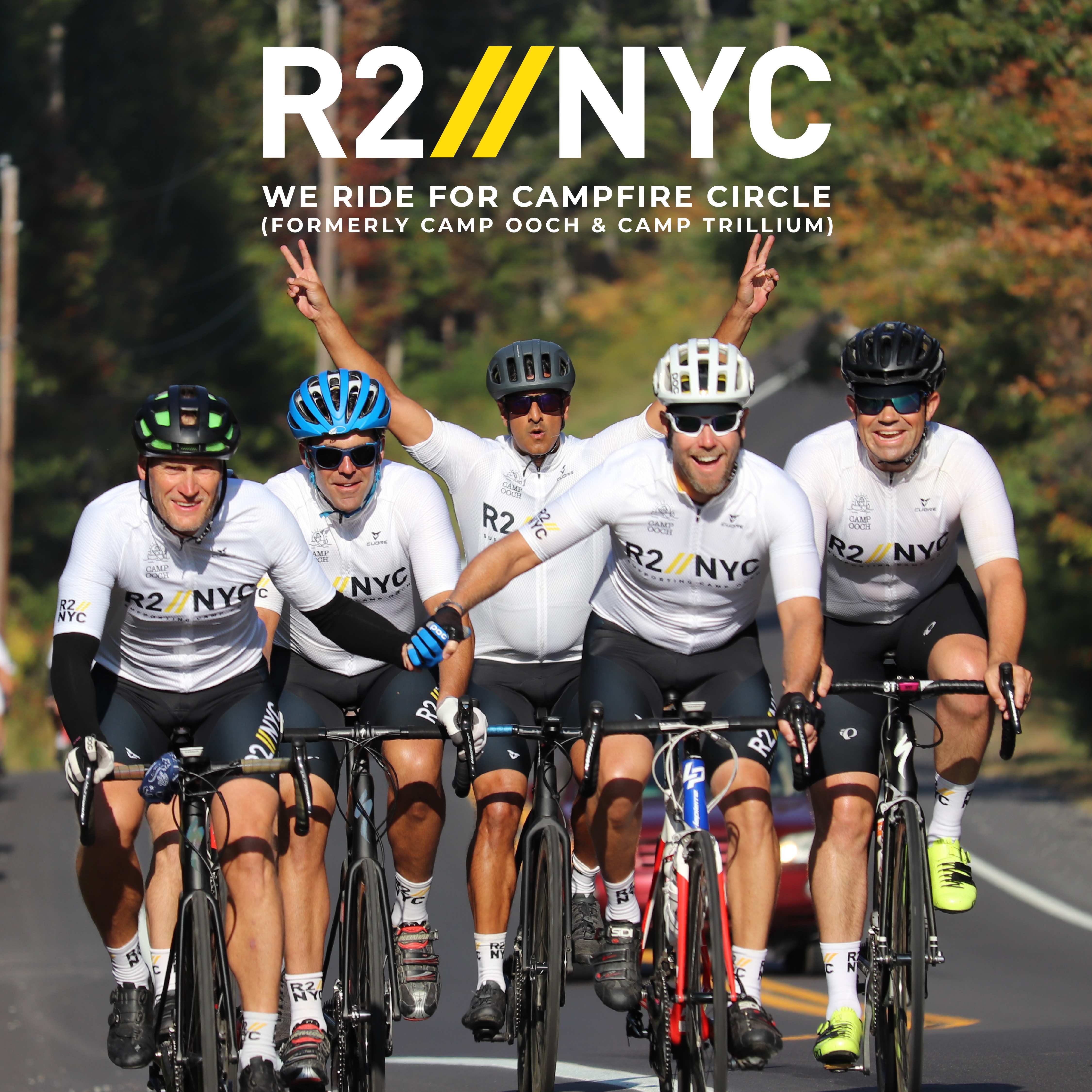 R2NYC We ride for Campfire Circle (Formerly Camp Ooch & Camp Trillium) Five riders on bikes smiling at camera on road with trees in background