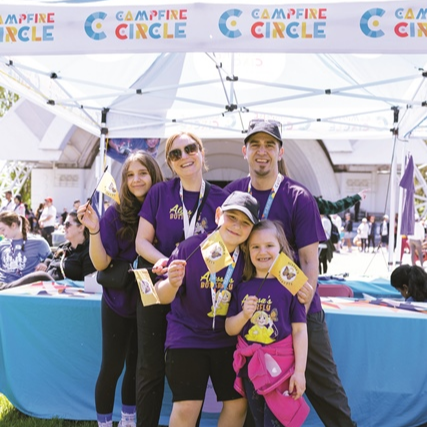 rao family standing together at campfire circle tent