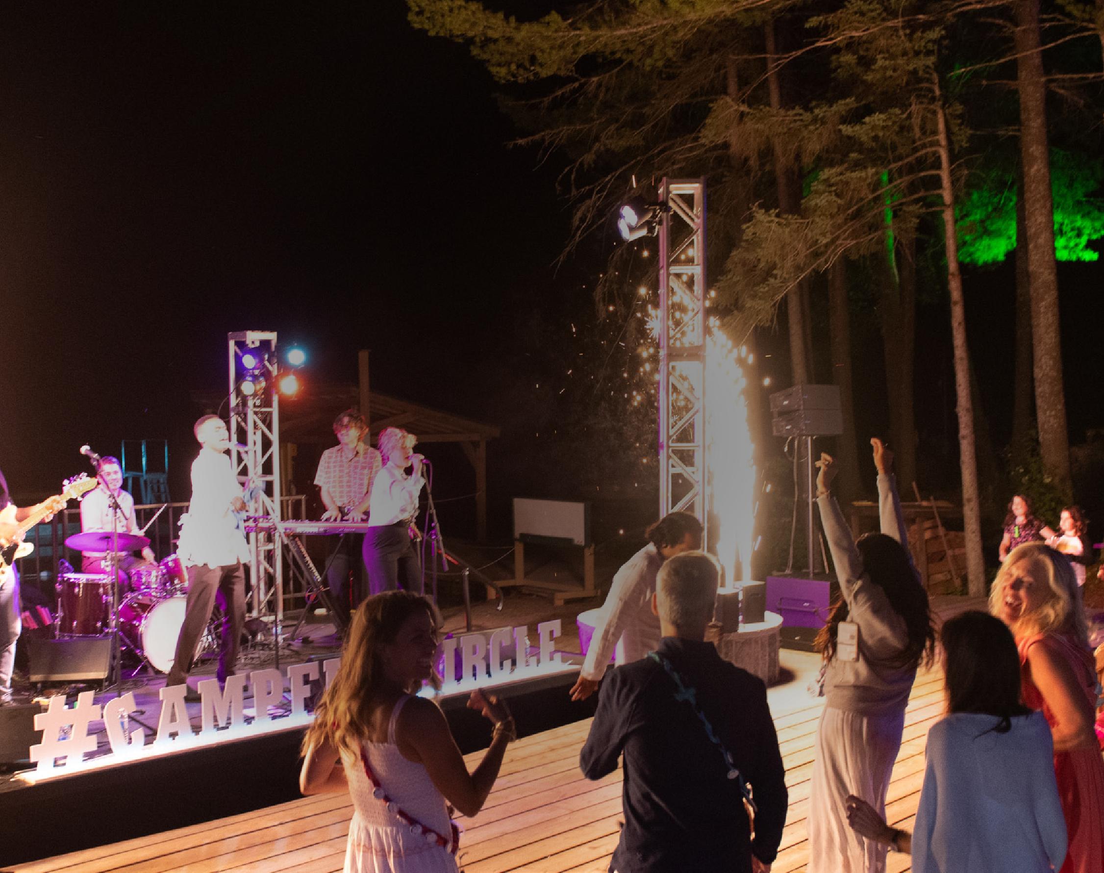 band performing on stage at night at camp