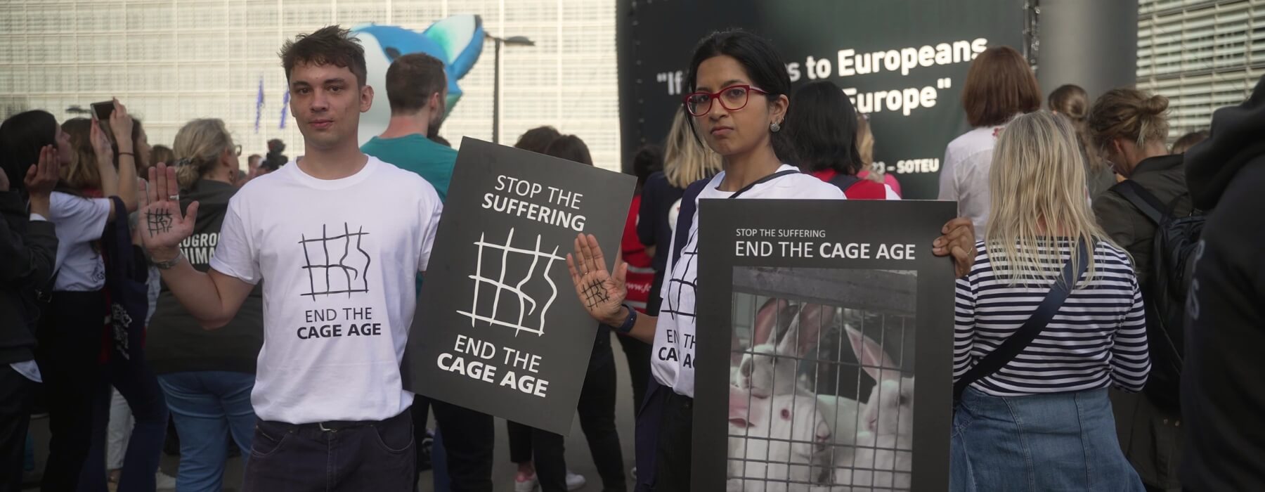 Una mujer y un hombre en una protesta con carteles que piden el fin de la Era d las Jaulas