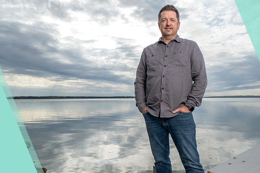 portrait of STARS Very Important Patient Wade Cassidy standing on the dock of the lake at his house where he required STARS critical care.