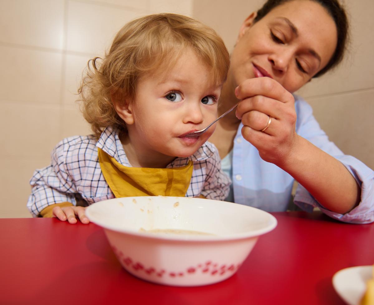 A mother feeding her child cereal