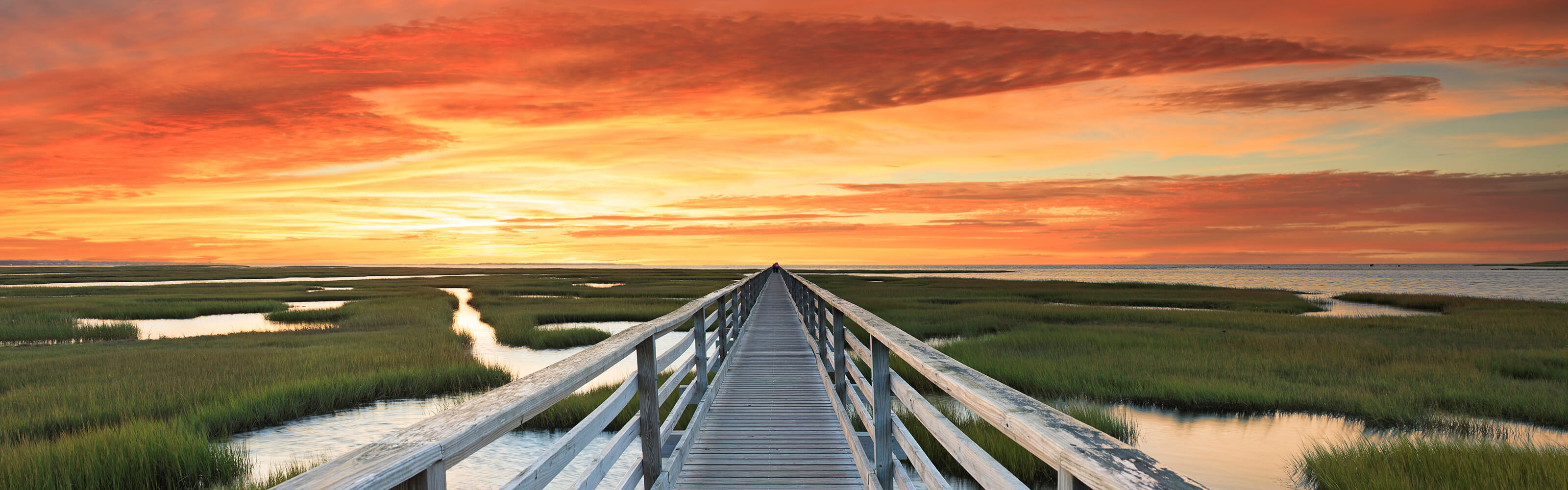 A bridge over marsh land during sunset