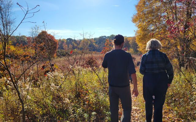 Two people walk through a prairie in autumn. © Bekah Wuchner/TNC