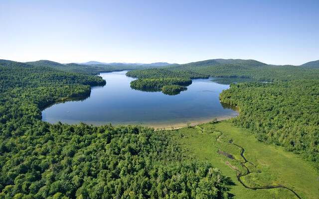 Aerial image of the 970-acre Follensby Pond surrounded by forests and wetlands. © Carl Heilman II