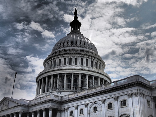 US Capitol building dome against a gray, cloudy sky