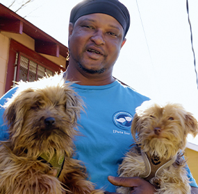 JaMaal Hughes holding two puppies