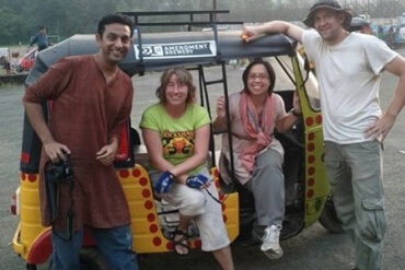 A group of four people standing around a rickshaw