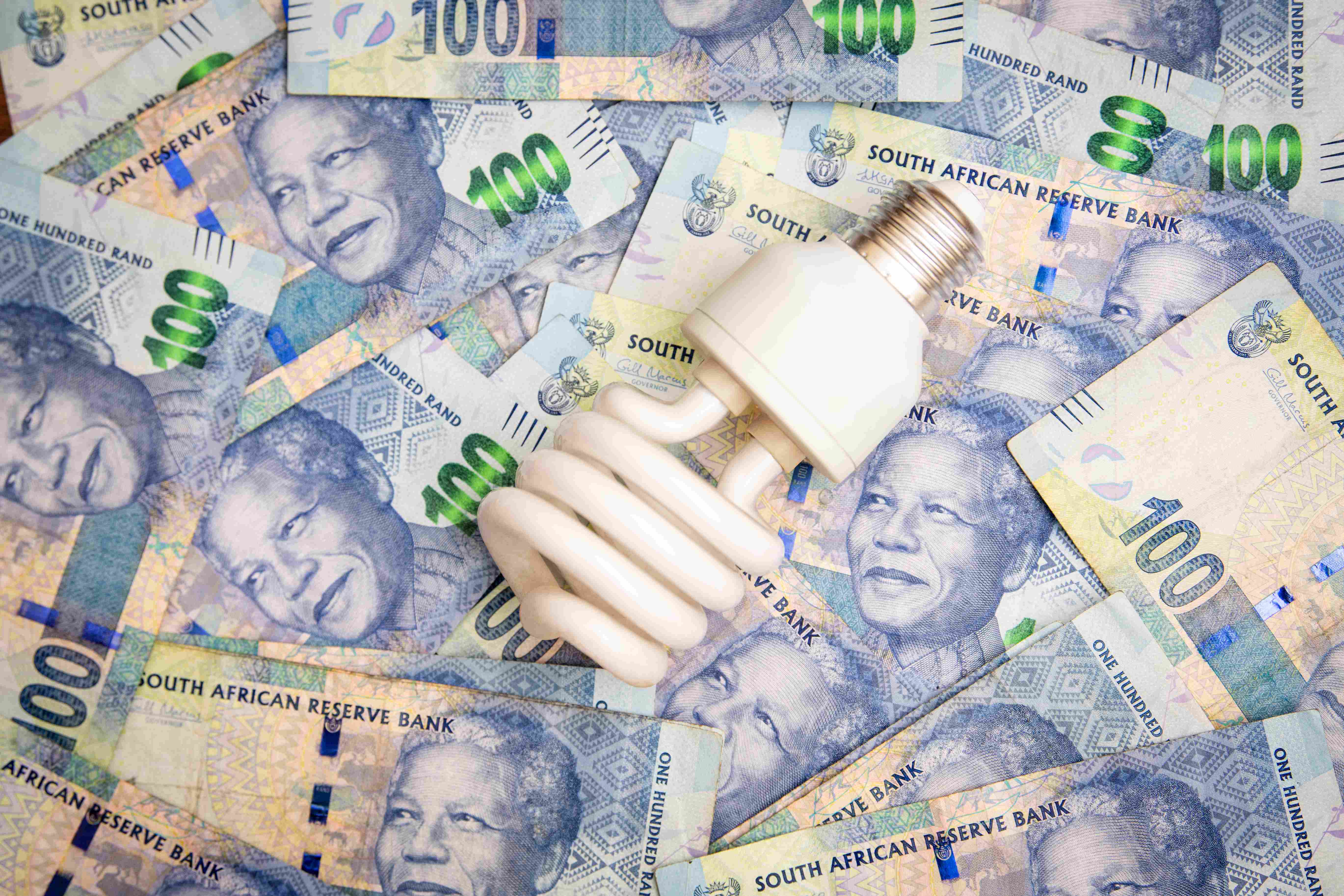 100 rand bills and an unscrewed light bulb
