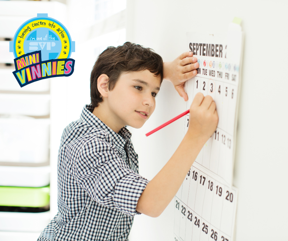 This is an image of a boy writing on a wall calendar