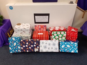 This is a photo of the Christmas shoeboxes put together by Mini Vinnies at Our Lady of the Wayside, Shirley, West Midlands for St Chad’s Sanctuary, a charity which supports asylum seekers and refugees in Birmingham. 