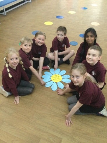 This is a picture of the Mini Vinnies at St Godric's around their forget-me-not flower