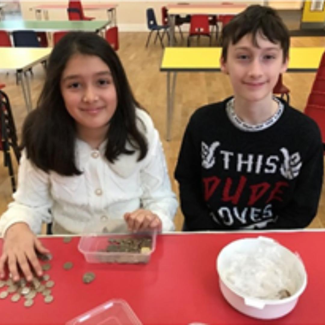 This is a photo of two Mini Vinnies from counting donations from their Advent Chore Chart.