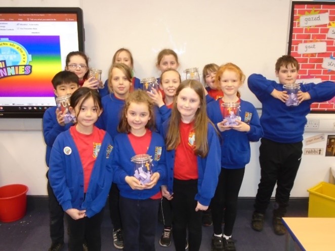 This is a picture of the Mini Vinnies holding their Lent jars