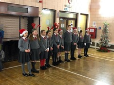 This is a photo of the Mini Vinnies at St Mary's, Beckenham singing Christmas carols at an SVP Christmas lunch.