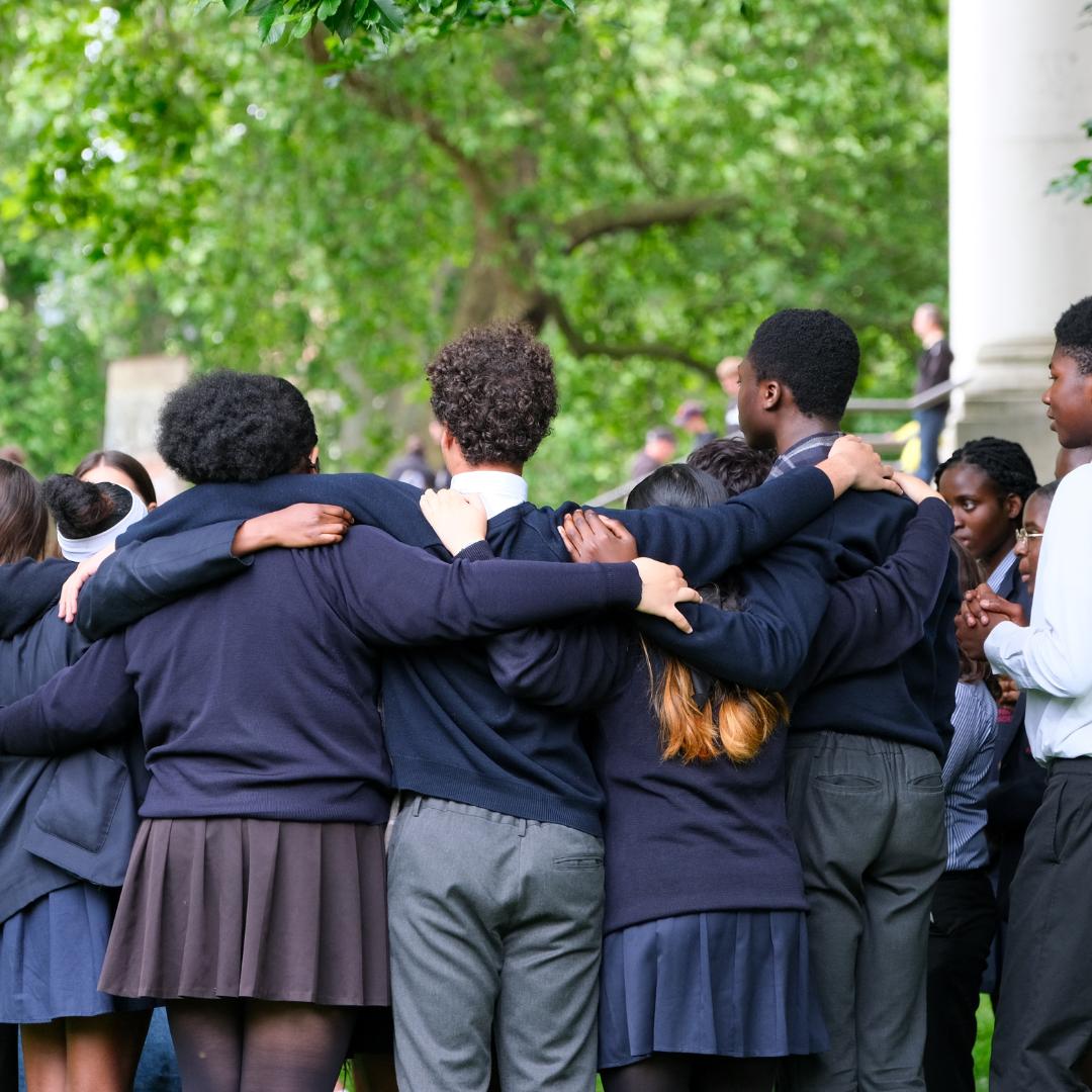 This is an image of some young people huddled together