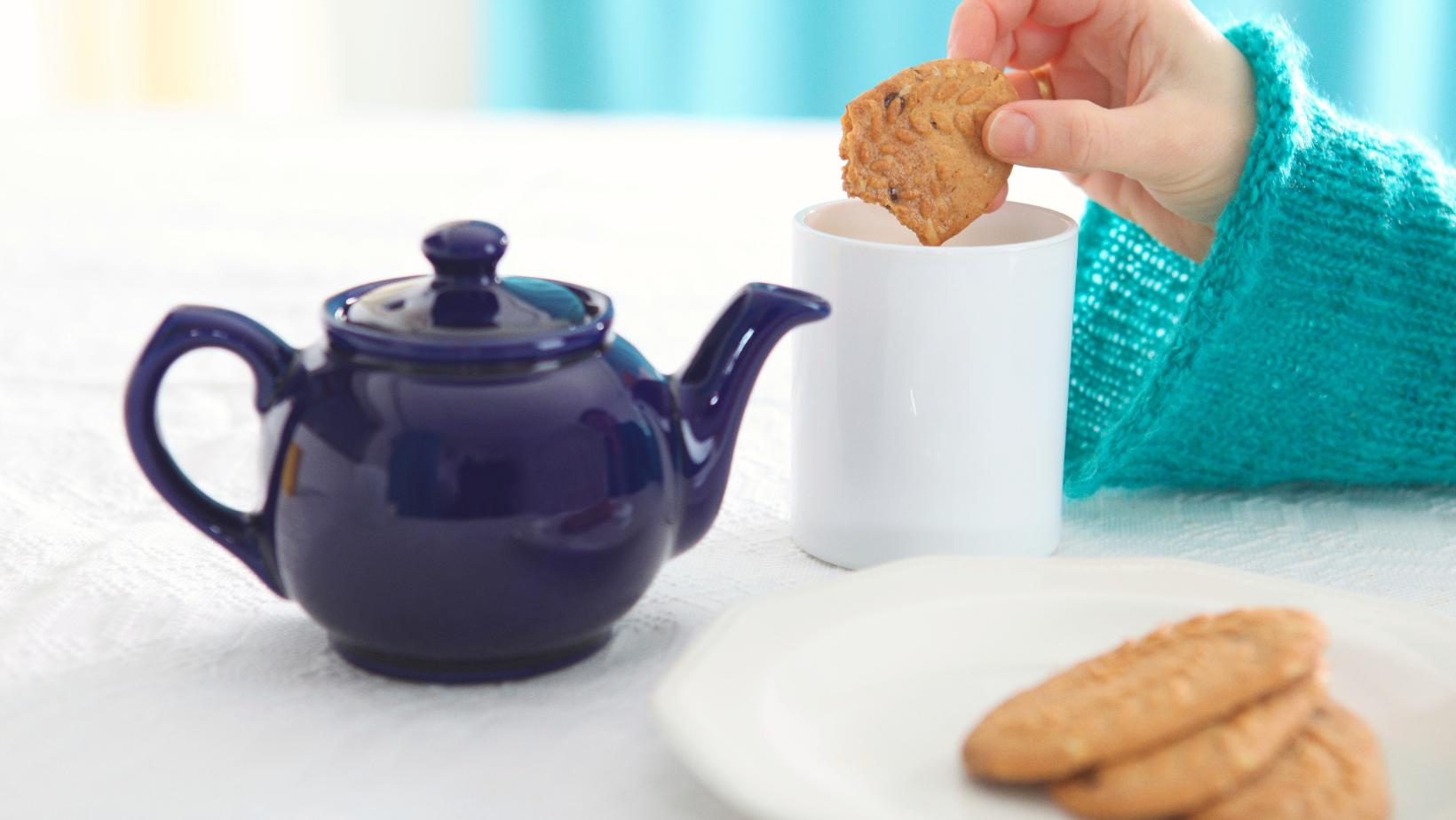 This is an image of someone dunking a biscuit in tea.