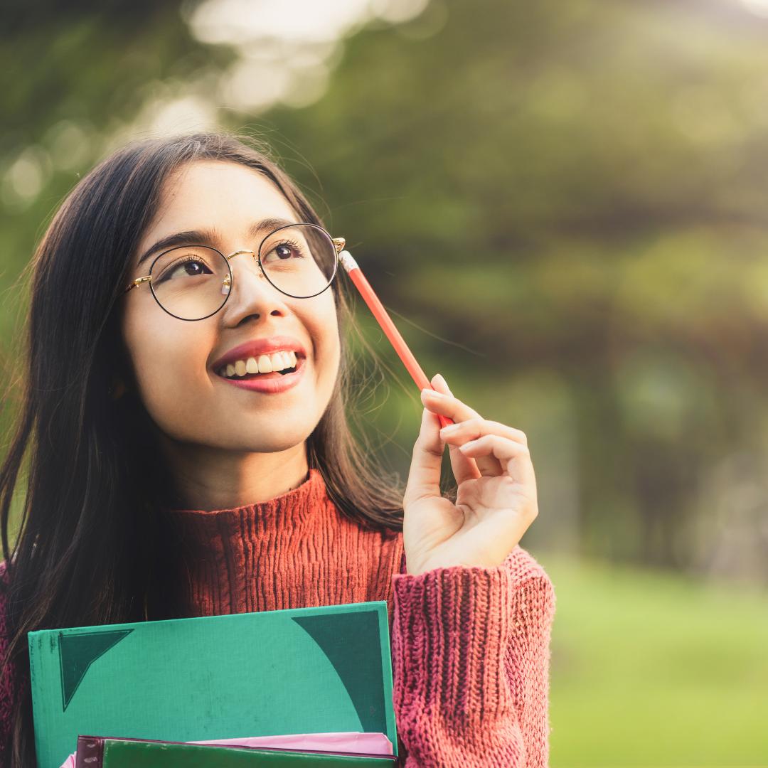 This is an image of a young person with a notebook and pencil