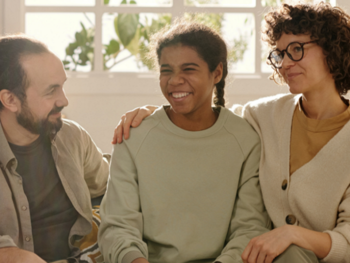 Girl smiling with a woman and a man next to her