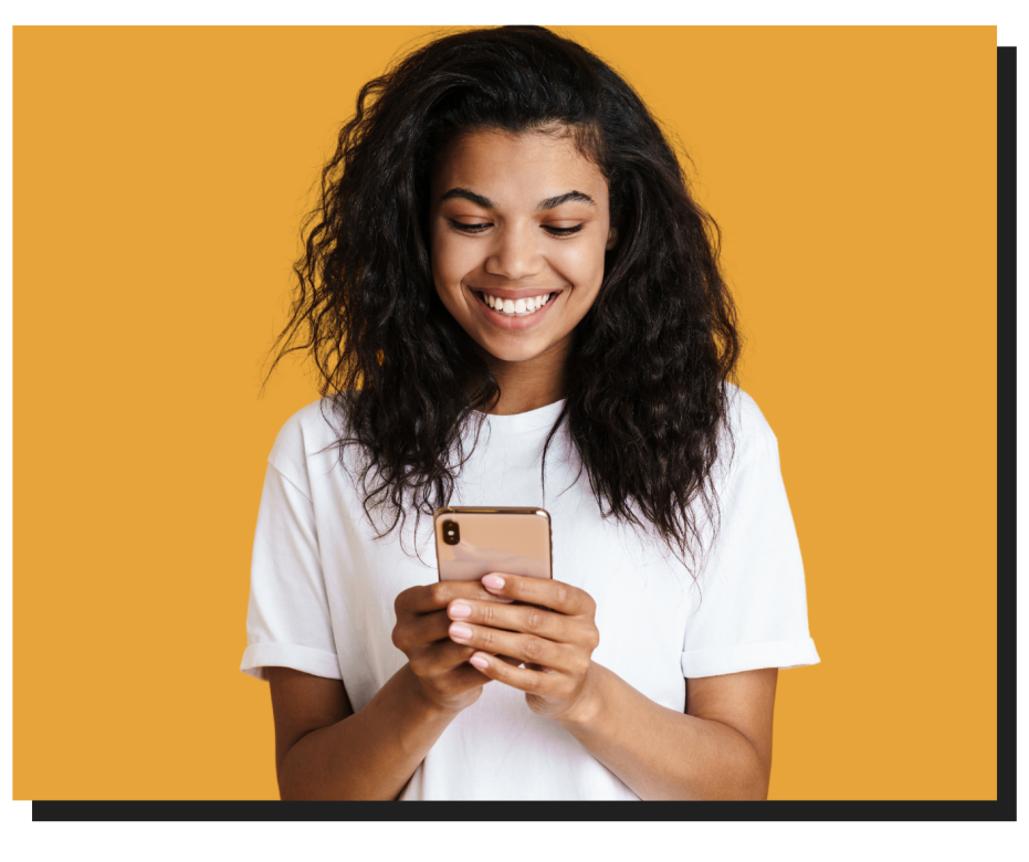 Woman holding a phone smiling while looking at it.