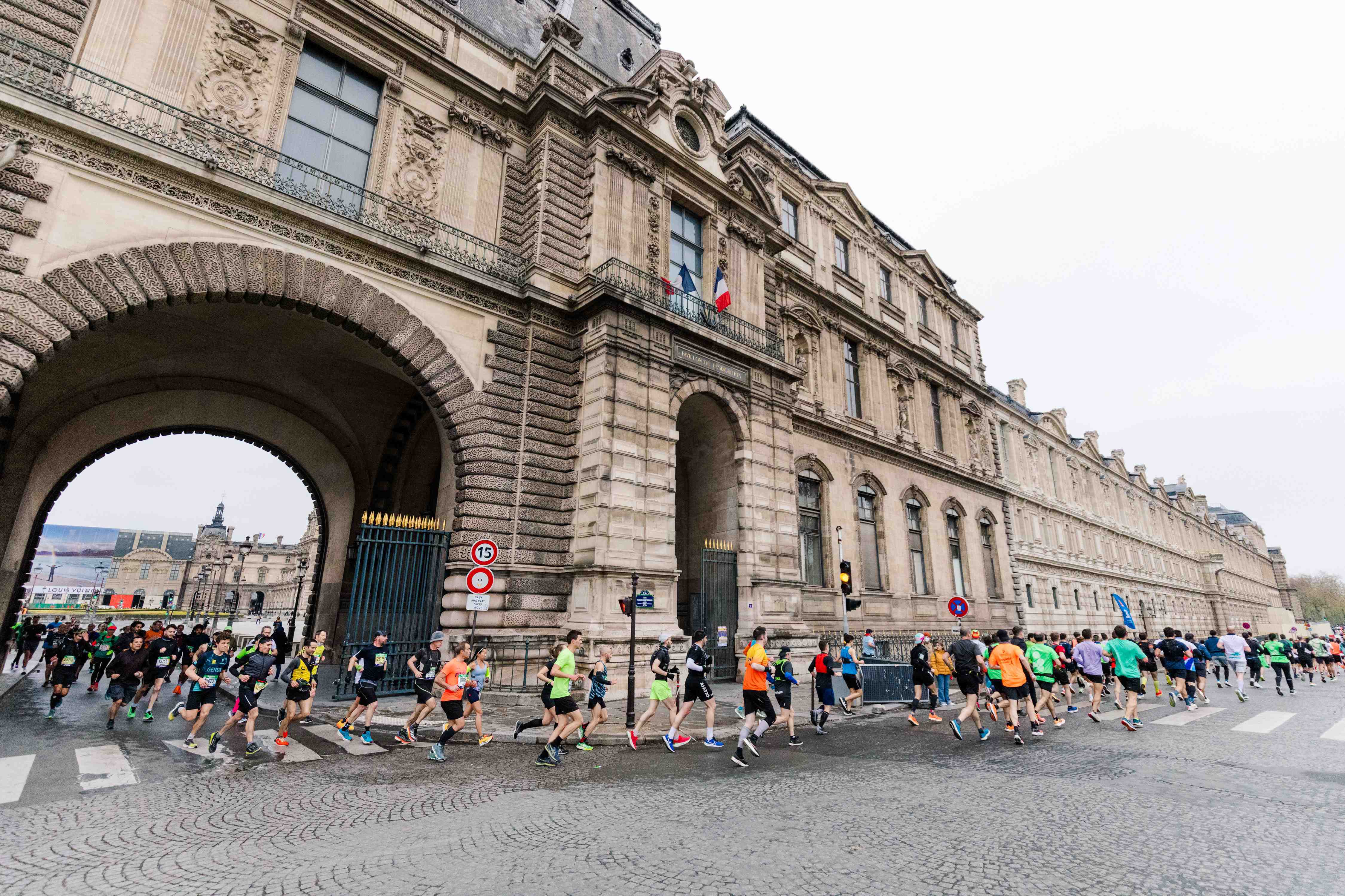 Runners under an arch at the Paris Marathon.